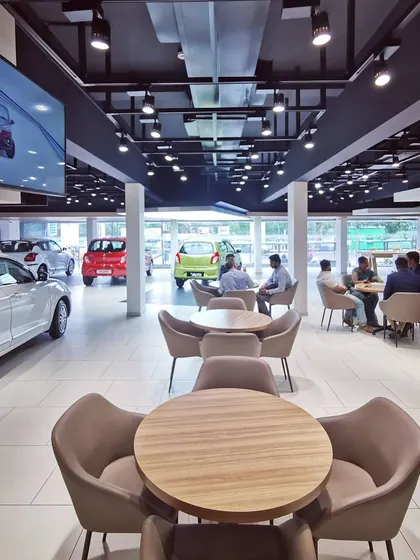 The customer consultation area within the Maruti Suzuki Arena. We designed these zones with comfortable seating and round tables to facilitate relaxed, informal conversations between sales staff and clients, moving away from traditional desk setups.