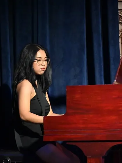 A student pianist delivering a powerful and emotional performance. Our piano curriculum is designed to develop both technical skill and artistic expression.