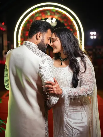 An intimate and romantic portrait of the couple, their foreheads touching, at their Sangeet.