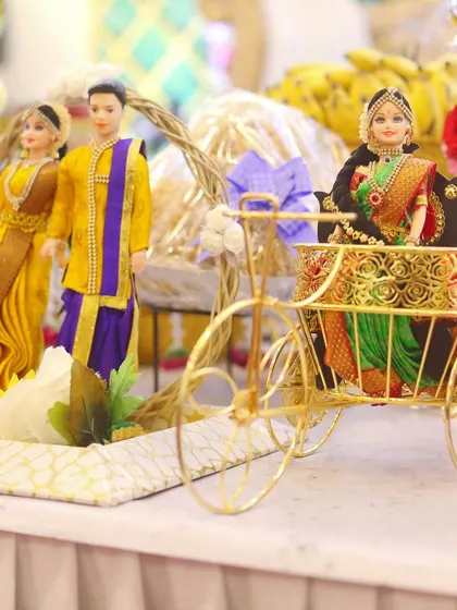 A beautiful doll arrangement featuring a couple and a doll seated in a miniature golden rickshaw. These creative props add a unique and memorable touch to any celebration.