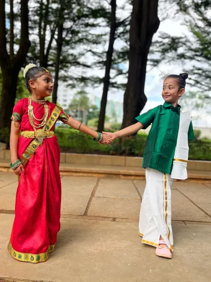 This level of cuteness should come with a warning label. Holding hands, these two friends are ready for a cultural performance.