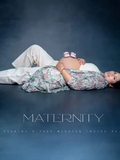 A creative and artistic portrait celebrating the little life on the way. The tiny shoes resting on the baby bump symbolize all the dreams and hopes for the future, captured in a beautifully styled studio maternity photo.