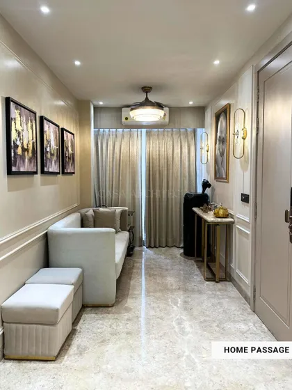 A view of a home passage or hallway, elegantly designed with a narrow sofa, console table, and artwork to make it more than just a thoroughfare.