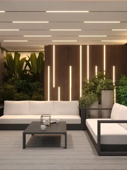 A luxurious indoor-outdoor seating concept with dramatic vertical lighting and lush plants.