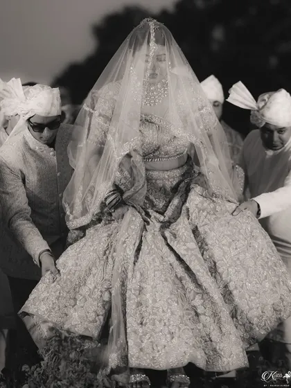 A timeless black and white shot of the bride being carried on a doli for her entrance.