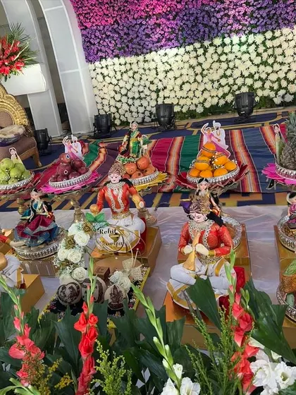 A vibrant platter display with a mix of traditional dolls and colorful floral arrangements.