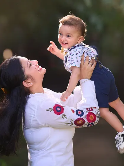 Lifting her world in her arms. This photo, taken during a pre-birthday shoot, beautifully captures a mother's love and the pure joy of her baby.