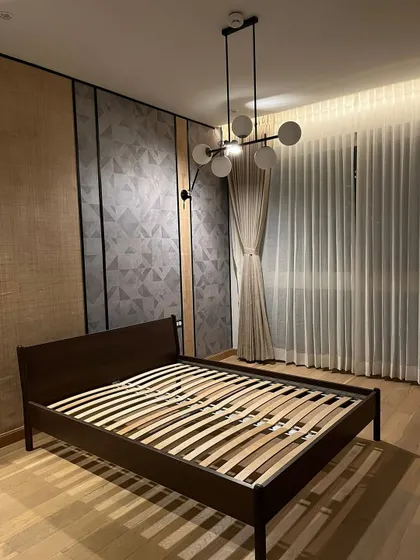 This bed frame is judging you for not having matching pillowcases. A modern bedroom with a statement wall featuring geometric patterns and wood paneling.
