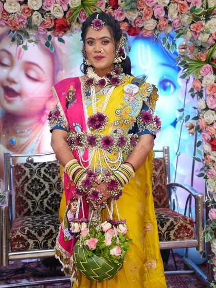 For this baby shower, I created a vibrant set using deep purple flowers and pearls. The full set, including the floral handbag, adds a beautiful pop of color against her yellow and pink saree.