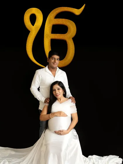 A spiritual and serene portrait for a Sikh family, incorporating the 'Ek Onkar' symbol to add a layer of personal faith and blessing to the maternity session.