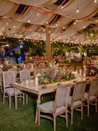 An evening reception designed to feel like a romantic night garden. We used long family-style tables, lush floral runners, and a canopy of draped fabric and string lights to create a warm and inviting atmosphere for dinner and conversation.
