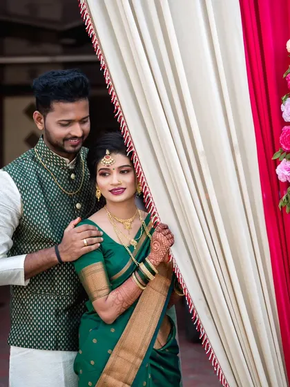 A classic couple portrait with the bride looking towards the camera. The soft lighting and floral decor create a romantic and polished look.