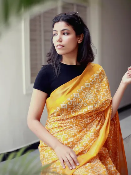 A thoughtful, poised shot in a yellow saree, demonstrating a calm and composed modeling style.