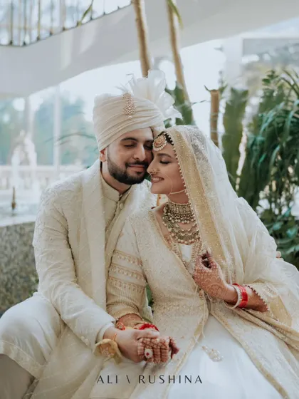 A beautiful, candid moment of the couple seated together. The groom's loving gaze and the bride's happy smile are perfectly captured, showcasing their natural chemistry.