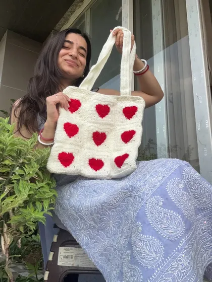 A happy shot of me with our classic red and white heart tote. It’s the perfect accessory to carry your love for handmade crafts.