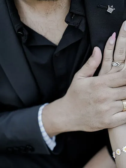 A close-up shot of a couple's hands, showing their rings and a gentle touch, symbolizing their commitment.