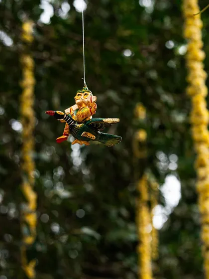 Another whimsical, hand-painted figurine, this time of a character flying on a mythical bird. Suspending these small treasures from branches creates a magical, forest-like atmosphere for guests to enjoy.