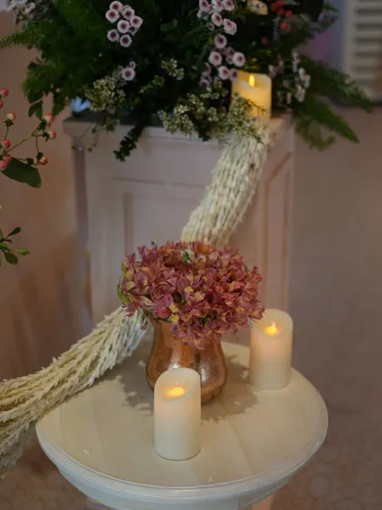 A small, thoughtful detail of candles and a delicate floral arrangement, adding to the romantic ambiance of the ceremony.