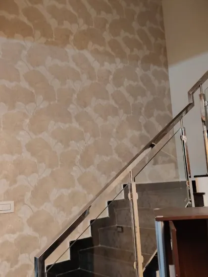 This staircase wall features a subtle, large-scale leaf pattern in a neutral tone. It adds texture and a modern organic feel to the space without overwhelming it.