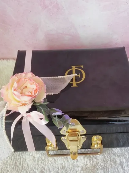 The elegant black trunk box used for our luxury Mother's Day hampers, adorned with a flower and ribbon.