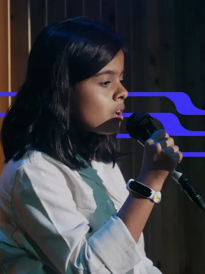 A young girl sings with focus and emotion. Our vocal lessons help students of all ages develop their voice and performance skills.
