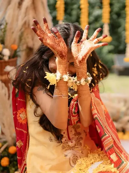 The bride showing off her beautiful mehendi-adorned hands, a key detail of the pre-wedding preparations.