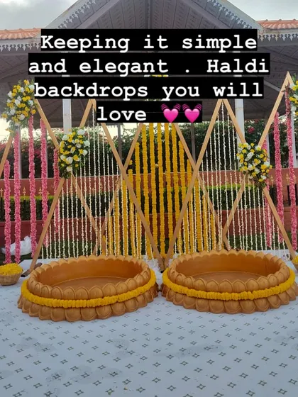 Keeping it simple and elegant. This Haldi backdrop with clean lines, floral strings, and traditional 'urli' seating is a design you and your guests will love.