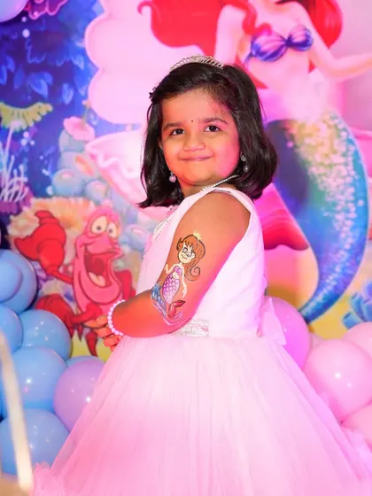 We also provide temporary tattoo artists for kids' parties. This guest is showing off her new mermaid tattoo, which perfectly matches the party's theme.