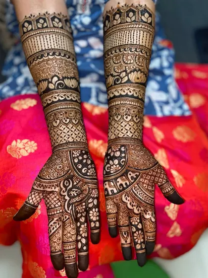 A beautiful design featuring elephant and paisley motifs on the palms, with traditional bands of patterns on the arms.