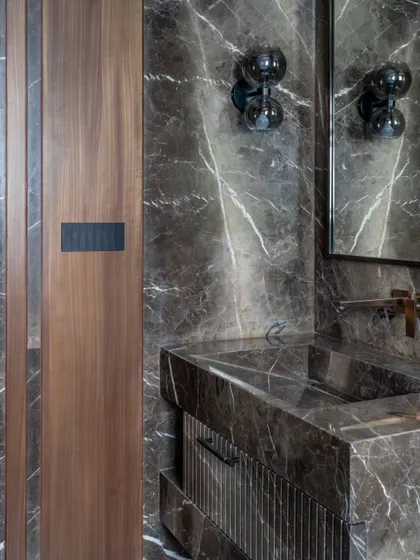 The custom walnut door with its integrated marble panel is a perfect example of our love for material interplay and bespoke details.