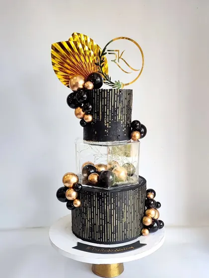 Another look at the stunning black and gold tiered cake, a true masterpiece for a modern wedding.