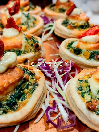 Our spinach and corn quiches topped with sun-dried tomatoes and a dollop of cream. These rich and flavorful bites are perfect for corporate lunches and formal gatherings.