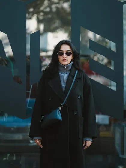 A shot of the model standing in front of a modern glass building. This image has a sleek, urban vibe, perfect for a contemporary fashion portfolio.