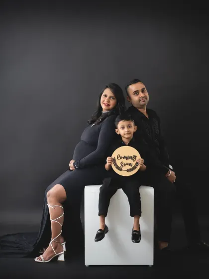 A sweet family pose where the focus is on the 'Coming Soon' sign held by the big brother. It’s a wonderful way to make older siblings feel important and involved.