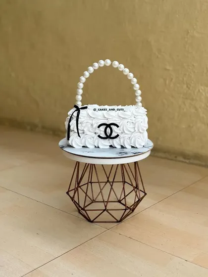 Yes, this is 100% a cake! We had so much fun sculpting this Chanel-inspired purse cake, complete with a pearl handle and rosette-style buttercream. Our workshops explore how to carve and structure novelty cakes that look just like the real thing.