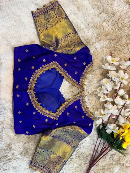 A royal blue silk blouse with a traditional zari border on the sleeves and a beautifully embroidered cut-out back.