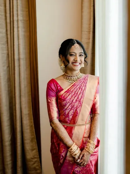 A full-length view of the South Indian bridal look, showing how the hair, makeup, and saree all come together to create a cohesive and stunning appearance.