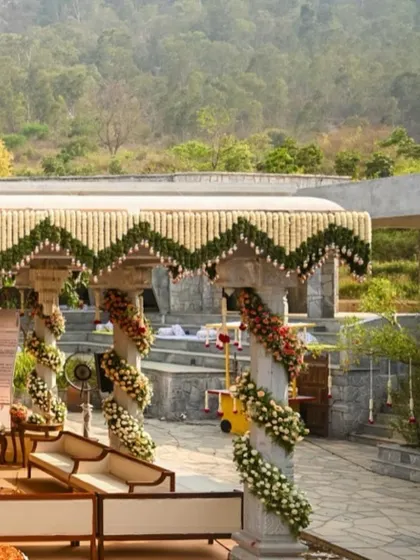 Another angle of the mountain-view mandap, highlighting the floral spirals on the pillars and the lush green surroundings.