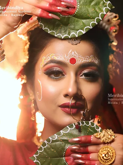 A creative shot where the bride holds betel leaves, a Bengali tradition, with a clear view of her intricate hairstyle and 'mukut'.