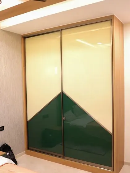 The daughter's bedroom in the Velachery project, featuring a two-tone sliding wardrobe in green and cream, creating a fresh and modern look.