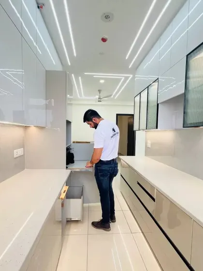 Demonstrating the pull-out bin and storage solutions in a new kitchen. Smart accessories like these are essential for keeping the kitchen organized and clutter-free.