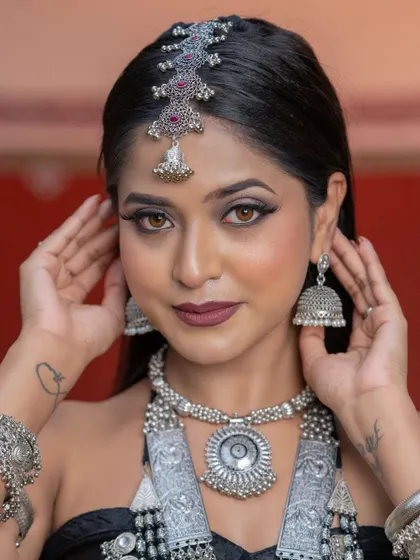 A beautiful shot of the model adjusting her jhumkas. This candid-style photo adds a dynamic feel to the student's portfolio.