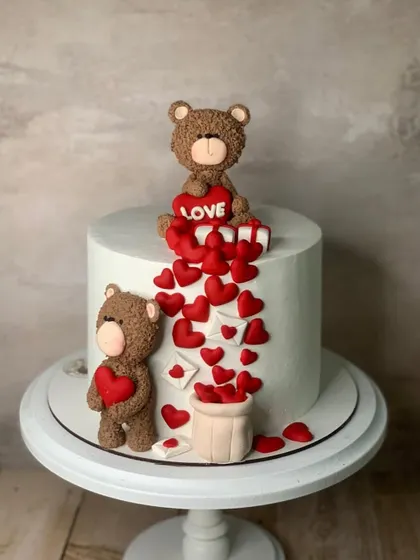 A cute love-themed cake with teddy bears and a cascade of hearts.