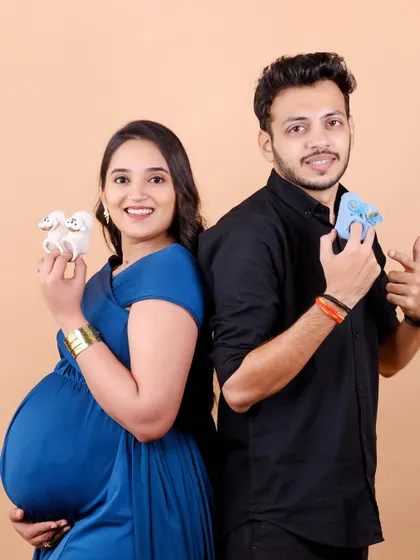 Boy or girl? A playful take on a gender reveal, with each parent holding a different colored baby shoe. It's a fun way to add some mystery and excitement to your maternity shoot.