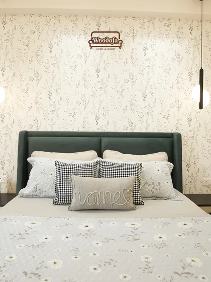 This bedroom feels like a warm hug. The combination of a dark green headboard, floral wallpaper, and patterned pillows creates a cozy, eclectic vibe. The "Home" cushion says it all.