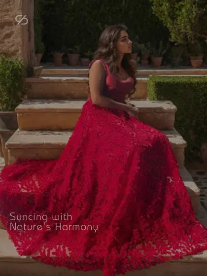 Embrace the inner radiance that forever shines. This magnificent red gown, with its textured 3D floral skirt, is designed to sync with nature's harmony and your own inner beauty.