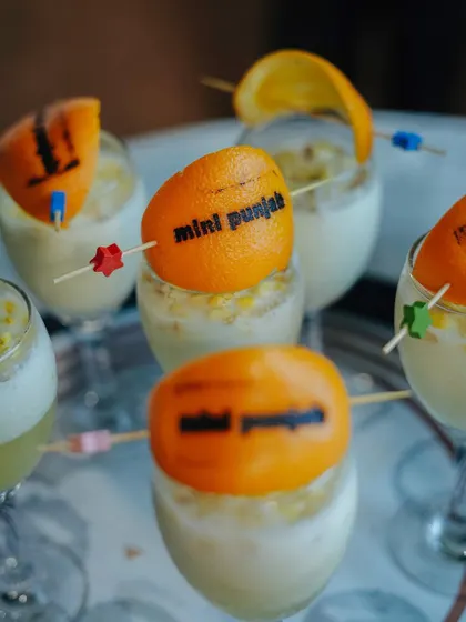 Our signature mocktails, branded with the Mini Punjab name on an orange peel garnish. This is an example of the small, creative details we add to make your event unique.