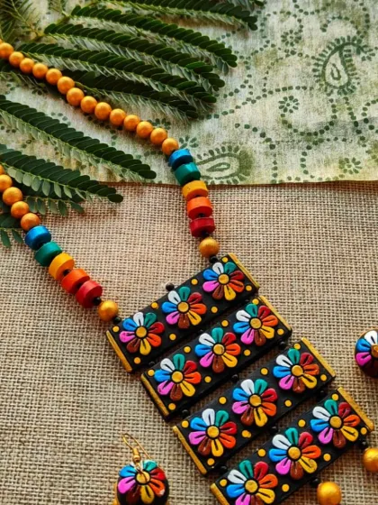 This rectangular pendant necklace features four layers of 3D multi-color floral motifs. It's a unique, structured design that is both playful and elegant.