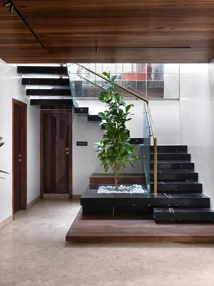 The cantilevered staircase, clad in black marble, is a central architectural feature of the duplex. I incorporated a small, skylit planter at its base, bringing a touch of nature indoors and creating a serene focal point.