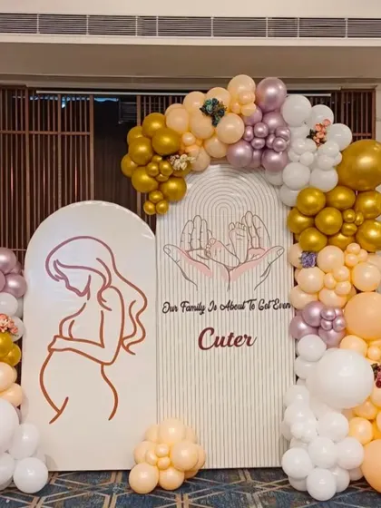 A modern and elegant baby shower setup. The line art of the mother-to-be and the 'Our Family is about to Get Cuter' sign add a personal and heartfelt touch.